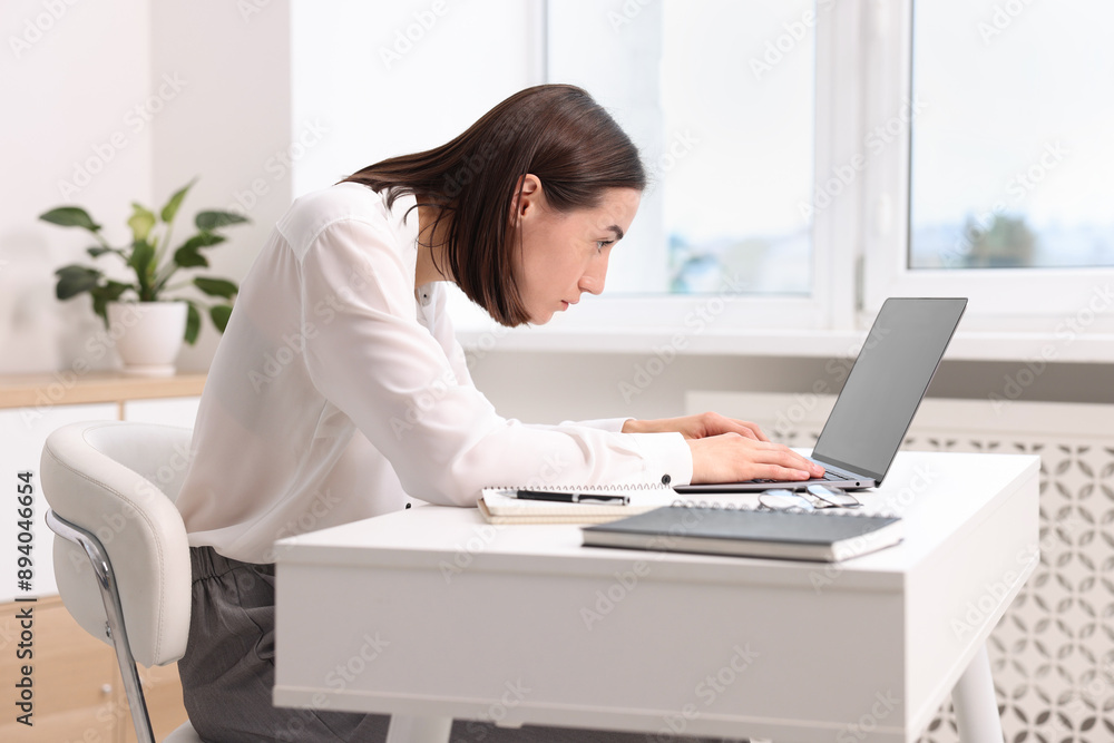 Woman with poor posture working in office Woman with poor posture working in office