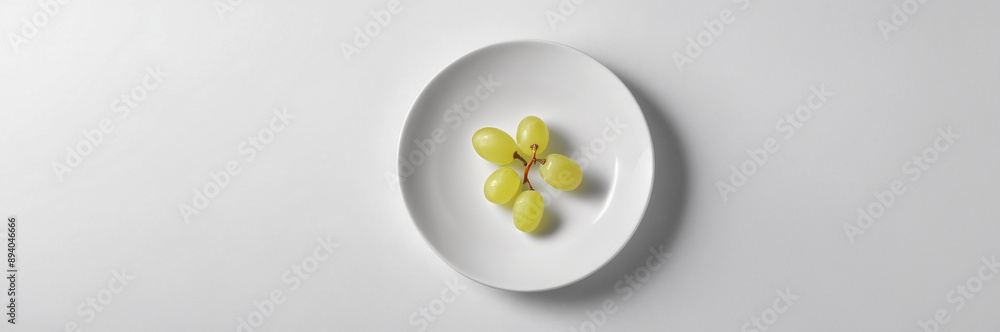 Green grapes arranged in a white bowl, showcasing fresh and juicy grapes for a healthy snack Green grapes arranged in a white bowl, showcasing fresh and juicy grapes for a healthy snack