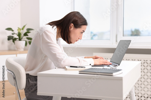 Woman with poor posture working in office