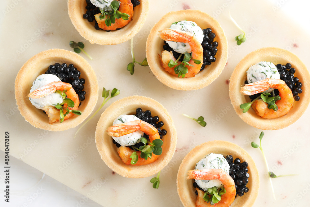 Delicious canapes with shrimps and black caviar on white table, top view Delicious canapes with shrimps and black caviar on white table, top view
