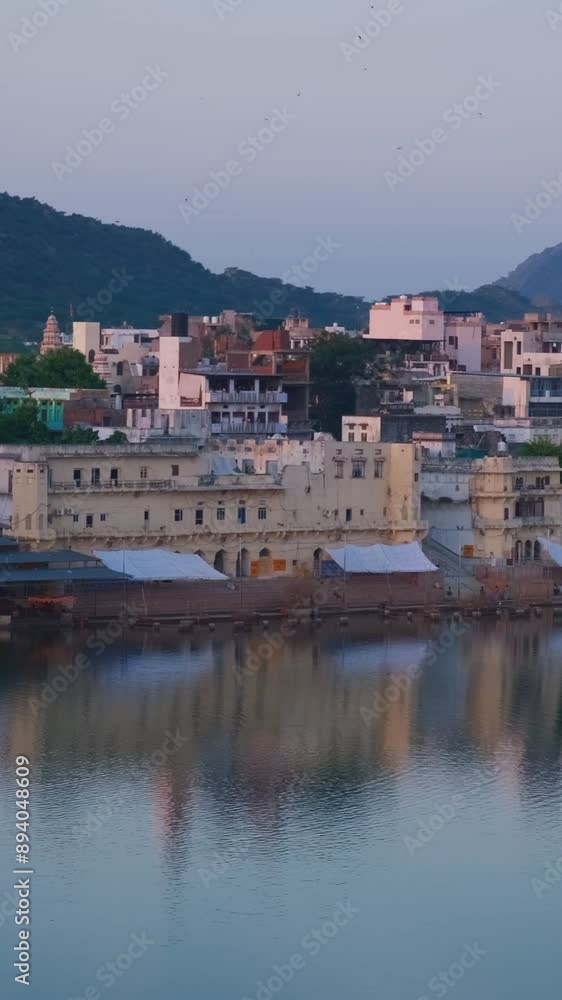 View of famous indian hinduism pilgrimage town sacred holy hindu religious city Pushkar with Brahma temple, aarti ceremony, lake and ghats illuminated at sunset. Rajasthan, India. Horizontal pan View of famous indian hinduism pilgrimage town sacred holy hindu religious city Pushkar with Brahma temple, aarti ceremony, lake and ghats illuminated at sunset. Rajasthan, India. Horizontal pan