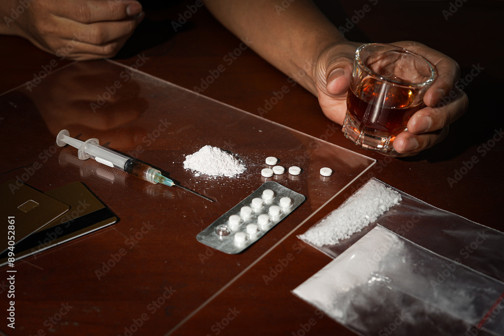 Alcohol drink in glass, syringe with drug dose, narcotic powder, Concept of addiction and bad habits Alcohol drink in glass, syringe with drug dose, narcotic powder, Concept of addiction and bad habits