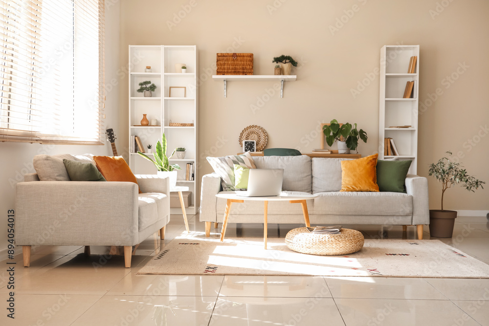 Interior of beautiful living room with grey sofas, houseplants, coffee table and shelving unit Interior of beautiful living room with grey sofas, houseplants, coffee table and shelving unit