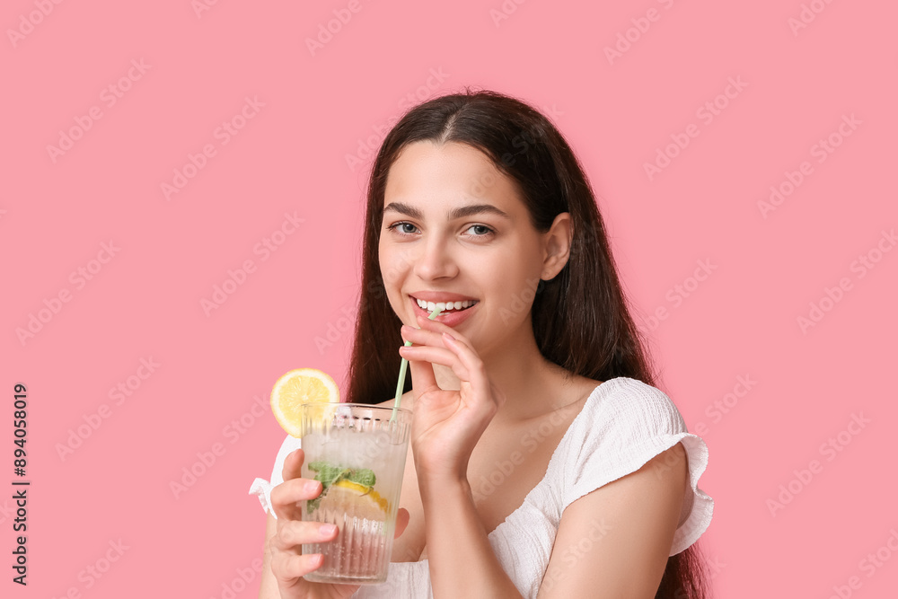 Beautiful young happy woman with glass of fresh lemonade on pink background Beautiful young happy woman with glass of fresh lemonade on pink background