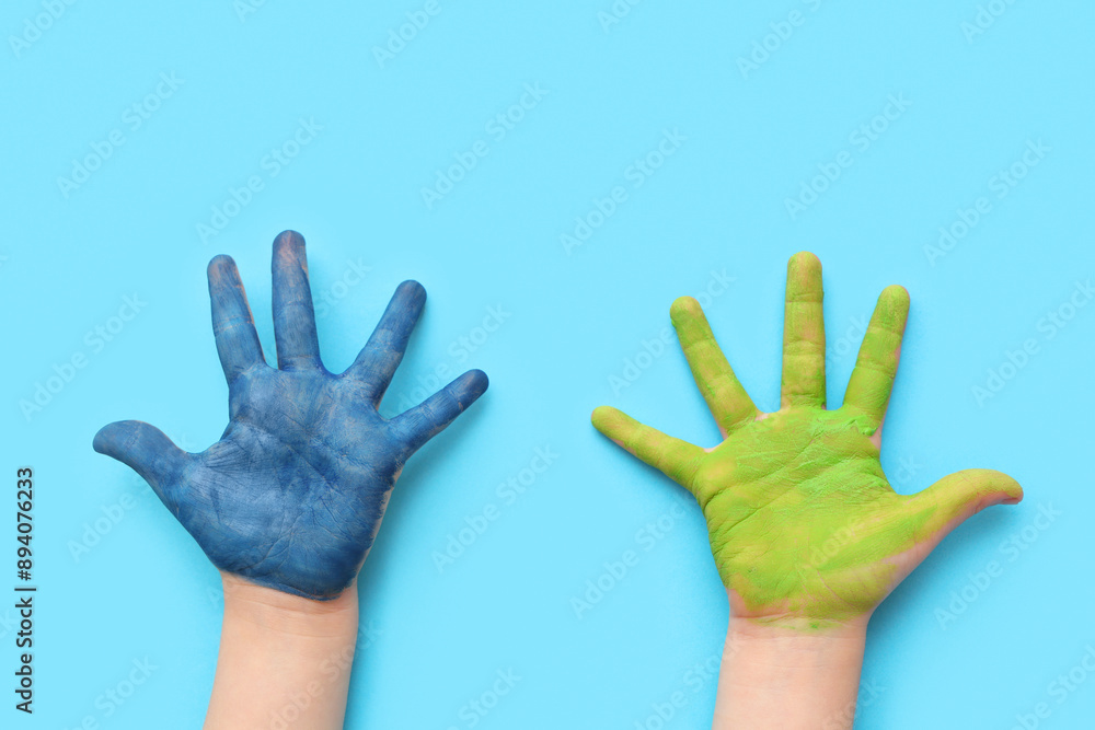 Child's hands in paint on color background, closeup Child's hands in paint on color background, closeup