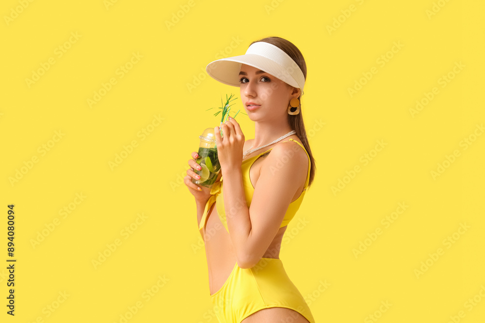 Φωτογραφία Beautiful young woman in swimsuit with cup of mojito on yellow background