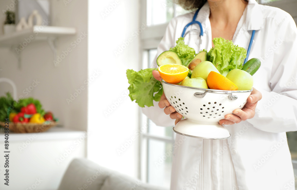 Mature female nutritionist with healthy food in kitchen, closeup Mature female nutritionist with healthy food in kitchen, closeup