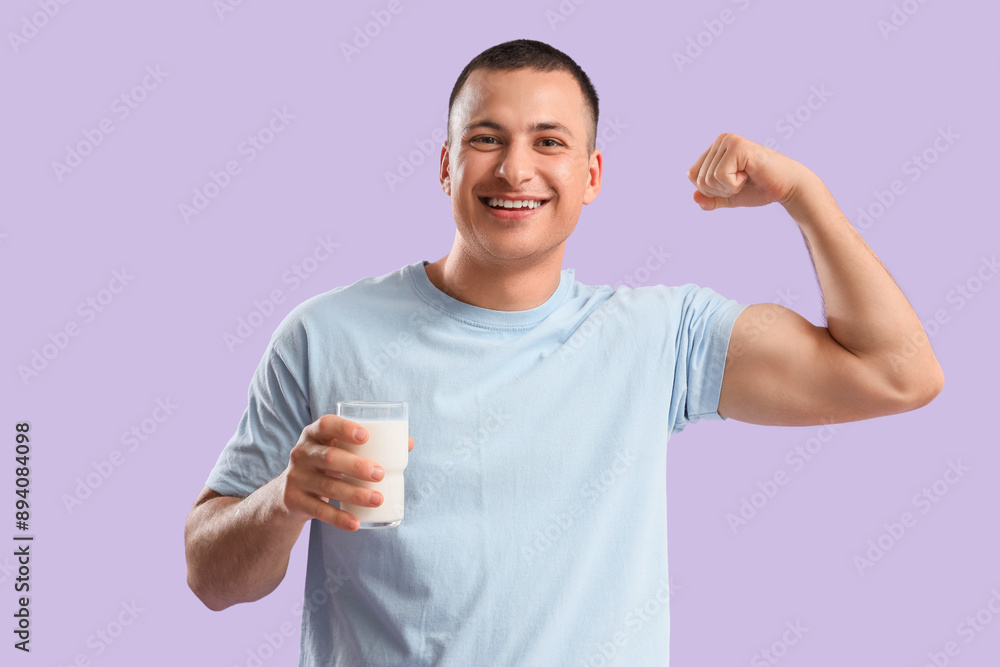 Young man with glass of milk showing muscles on lilac background Young man with glass of milk showing muscles on lilac background