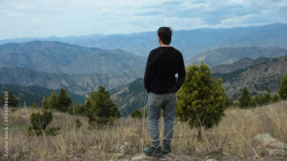 Video of a young man standing by himself in a calm, natural forest setting, looking sad and lonely. Video of a young man standing by himself in a calm, natural forest setting, looking sad and lonely.
