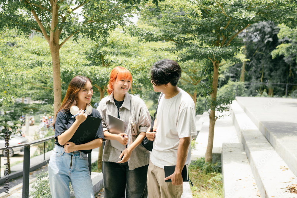 Group of Happy Students Socializing Outdoors on Campus with Laptops and Notebooks, Engaging in Friendly Conversation Group of Happy Students Socializing Outdoors on Campus with Laptops and Notebooks, Engaging in Friendly Conversation