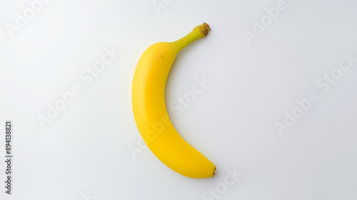 Single fresh yellow banana on a plain white background, ideal for showcasing the simplicity and natural beauty of this popular fruit, perfect for food presentations or health and nutrition content