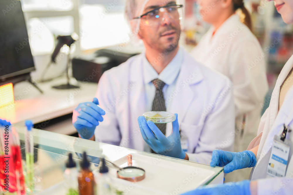 scientists perform experiments and record data. people arranges equipment with test tubes and chemicals for producing medicine and biochemistry. man hold tubes of chemical liquids and plant samples. scientists perform experiments and record data. people arranges equipment with test tubes and chemicals for producing medicine and biochemistry. man hold tubes of chemical liquids and plant samples.
