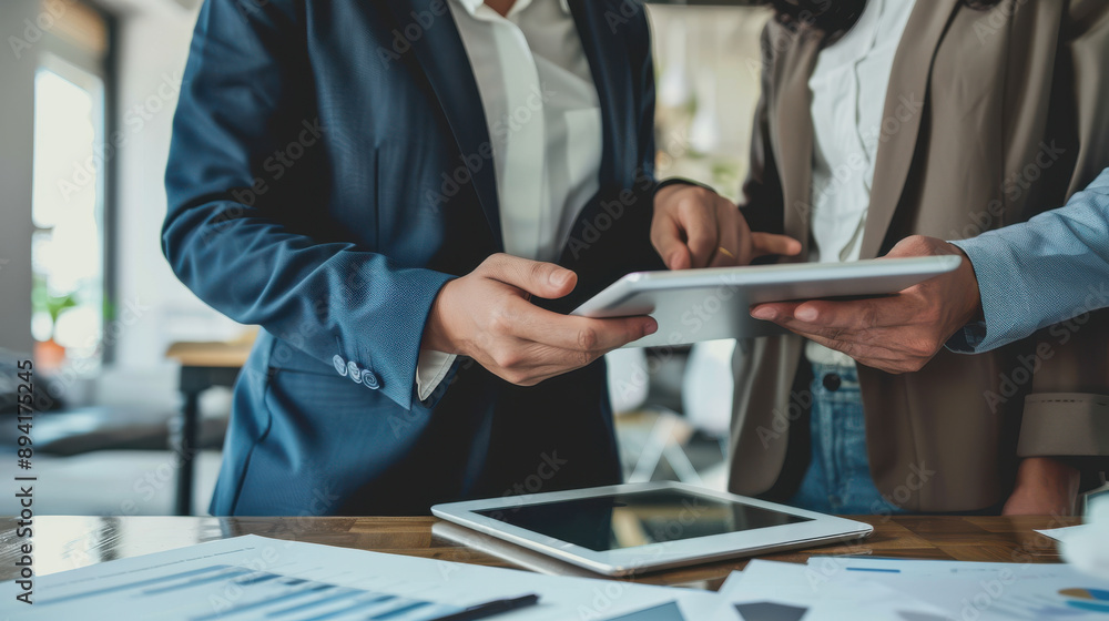 Clients viewing property listings on a tablet with their real estate agent, digital marketing in real estate Clients viewing property listings on a tablet with their real estate agent, digital marketing in real estate