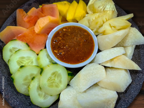 Close up shot of Indonesian fruit salad served with peanut sauce. Also known as rujak buah or lotis. The fruits consist of cucumber, jicama, young papaya, pineapple, and mango. photo