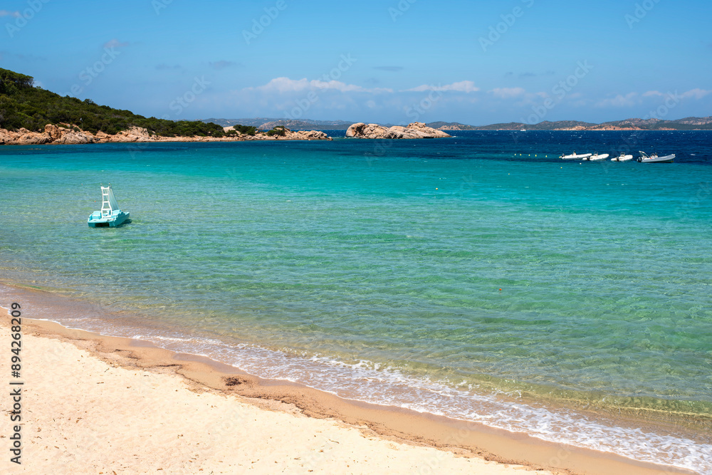 Fototapeta premium View of the beach of Baia Sardinia, a tourist resort in northern Sardinia Island, famous for the clarity of the sea waters and the beauty of the surrounding landscape.