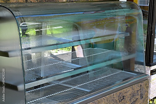 Billede på lærred Empty refrigerated display case in a cafe closed at the end of the season