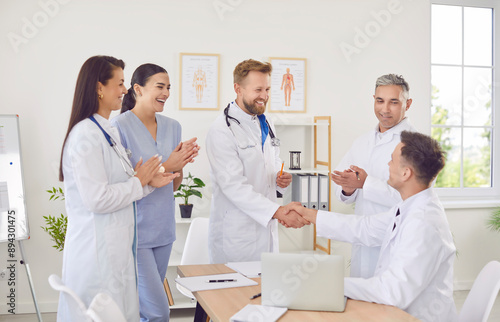 Картината върху платно Team of positive doctors and nurses engages in a handshake during a productive meeting in the hospital