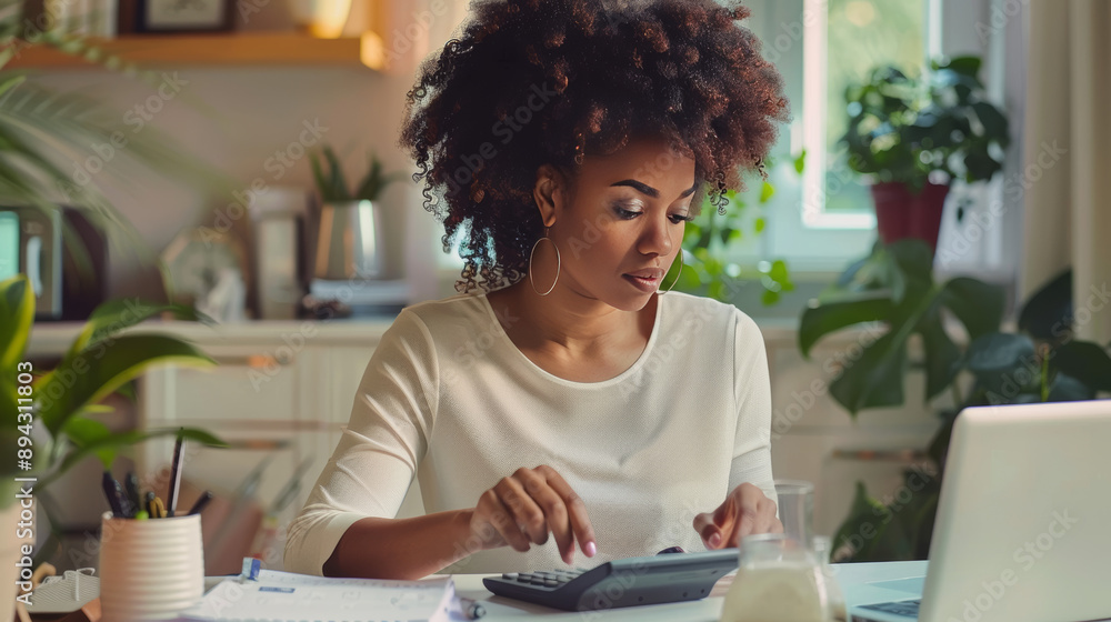 A woman works at her home office, calculating financial data and using a calculator. This photo represents the accounting and banking processes that are important for businesses. A woman works at her home office, calculating financial data and using a calculator. This photo represents the accounting and banking processes that are important for businesses.