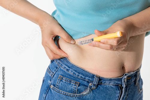 A woman injecting herself with obesity medication
