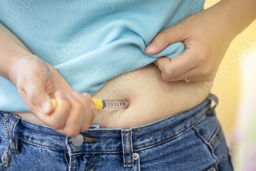 A woman injecting herself with obesity medication photo