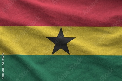 Ghana flag depicted on folded wavy fabric of old cloth close up photo