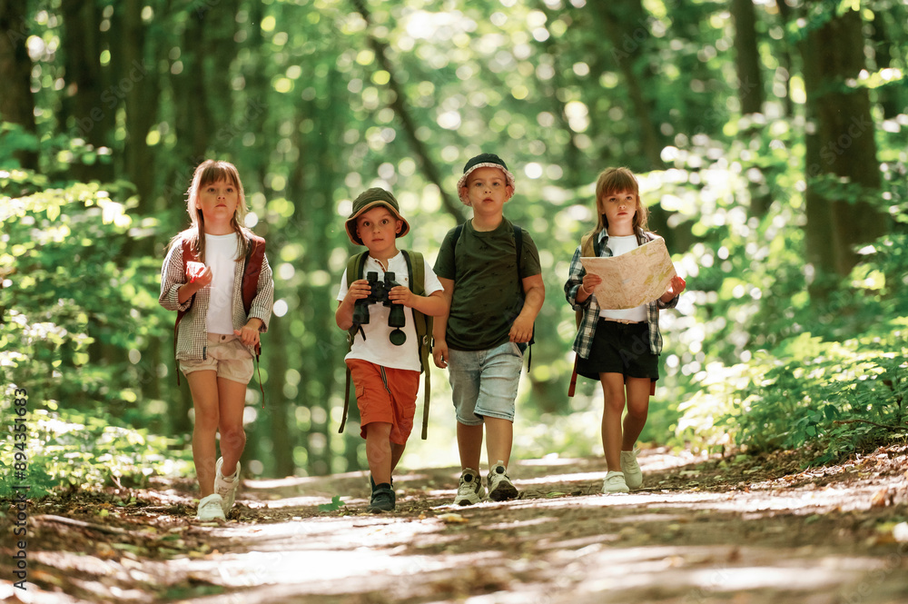 Conception of hiking. Kids in forest at summer daytime together Conception of hiking. Kids in forest at summer daytime together