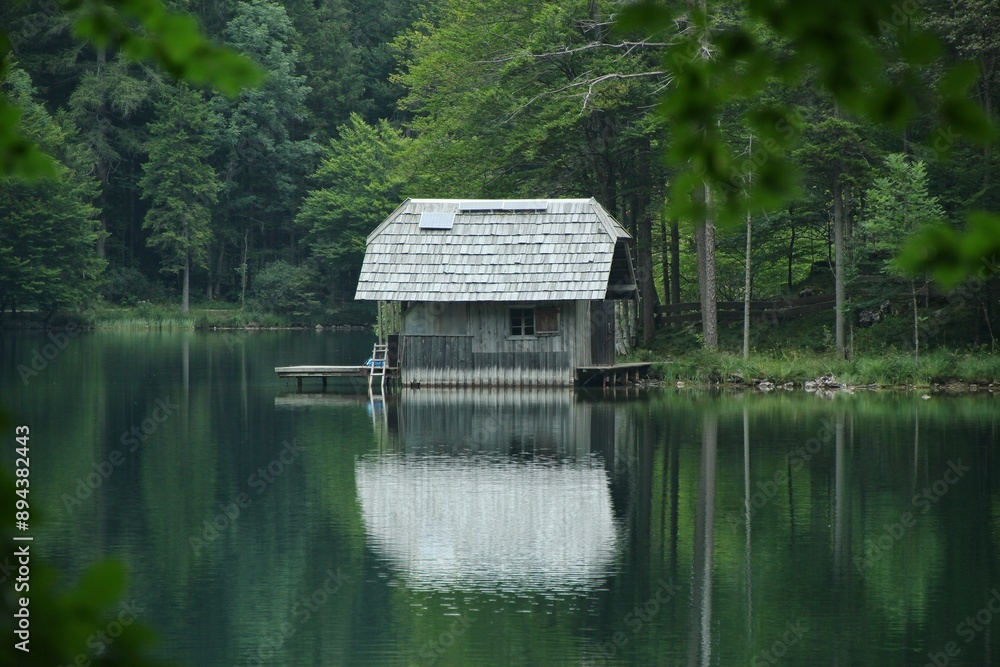 Obraz premium A house by the lake among the tree in Austria Alps