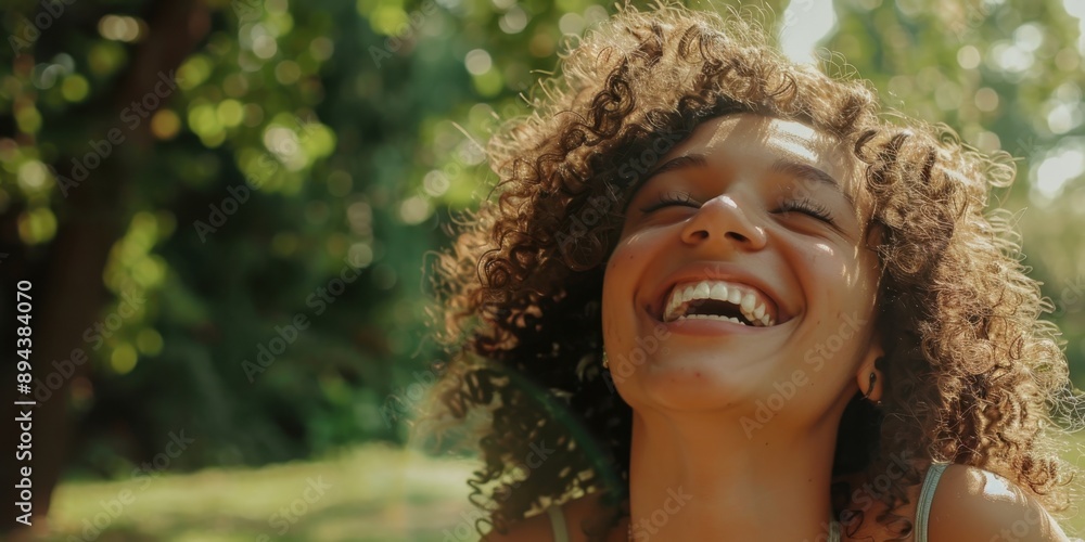 Laughing woman with curly hair in grassy field. Joyful outdoor moment. Laughing woman with curly hair in grassy field. Joyful outdoor moment.