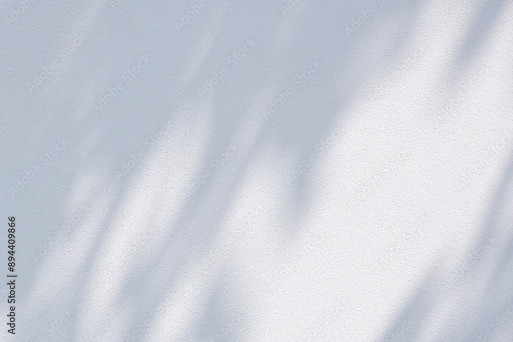 White cement wall background with sunlight and tree branch shadow on surface