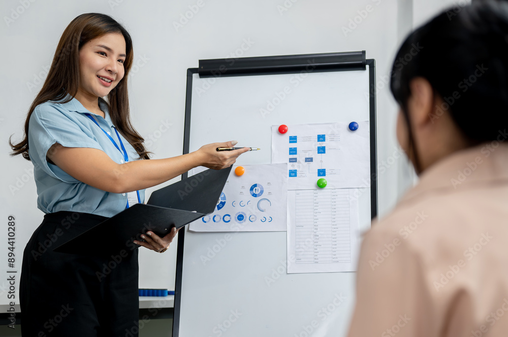 A confident Asian female analyst is leading the meeting and presenting her business analysis. A confident Asian female analyst is leading the meeting and presenting her business analysis.