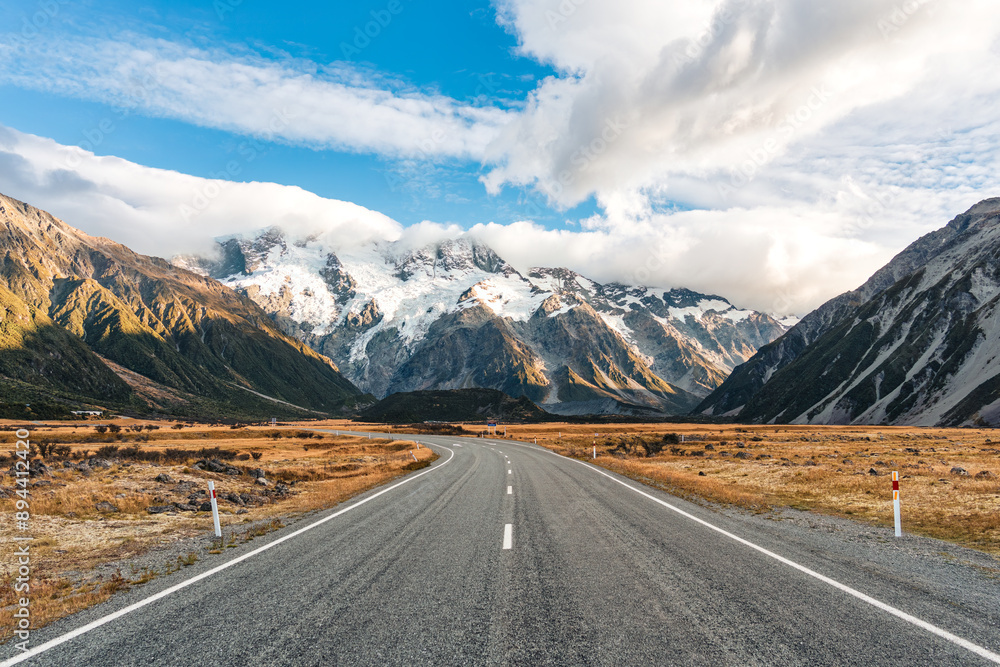 Fototapeta premium Road trip with asphalt road leading to Mt Cook with snow capped among grassland in national park at New Zealand