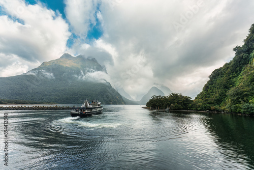 Ferry cruising with mountain in fjord at Milford Sound, New Zealand photo