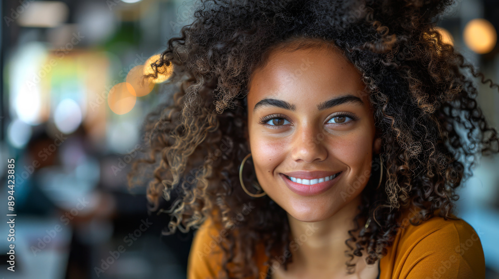 Portrait of a young curly woman in a bright jacket at her desk in a modern office. Lifestyle. Portrait of a young curly woman in a bright jacket at her desk in a modern office. Lifestyle.