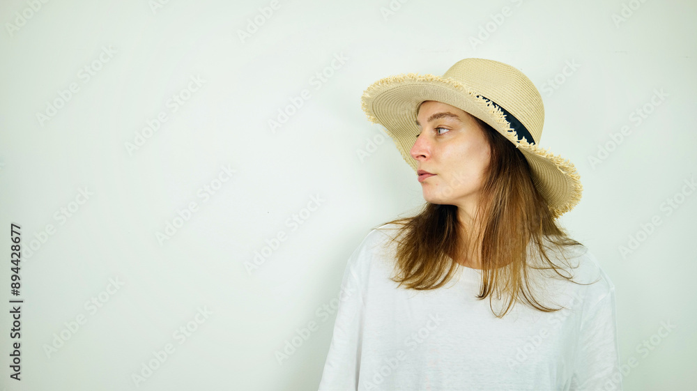 Portrait of beautiful Caucasian young female model with blue eyes, straw hat and white shirt, fashion and lifestyle, isolated on white background, copy space area