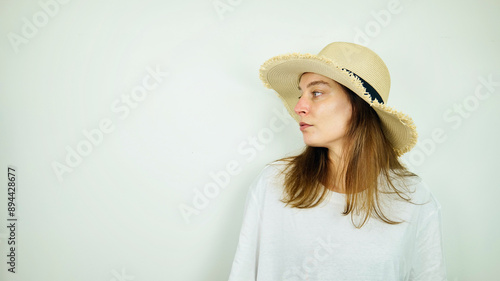 Obraz na płótnie Portrait of beautiful Caucasian young female model with blue eyes, straw hat and white shirt, fashion and lifestyle, isolated on white background, copy space area w salonie