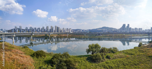 Sejong-Si, South Korea - October 30, 2022: Panoramic and autumnal view of Geumgang Pedestrian Bridge on Geumgang River against apartments
 photo