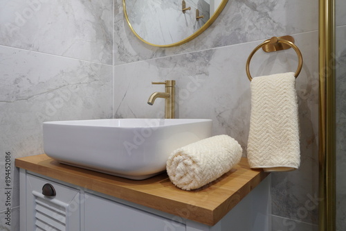 modern hotel bathroom sink and towel with gold faucet