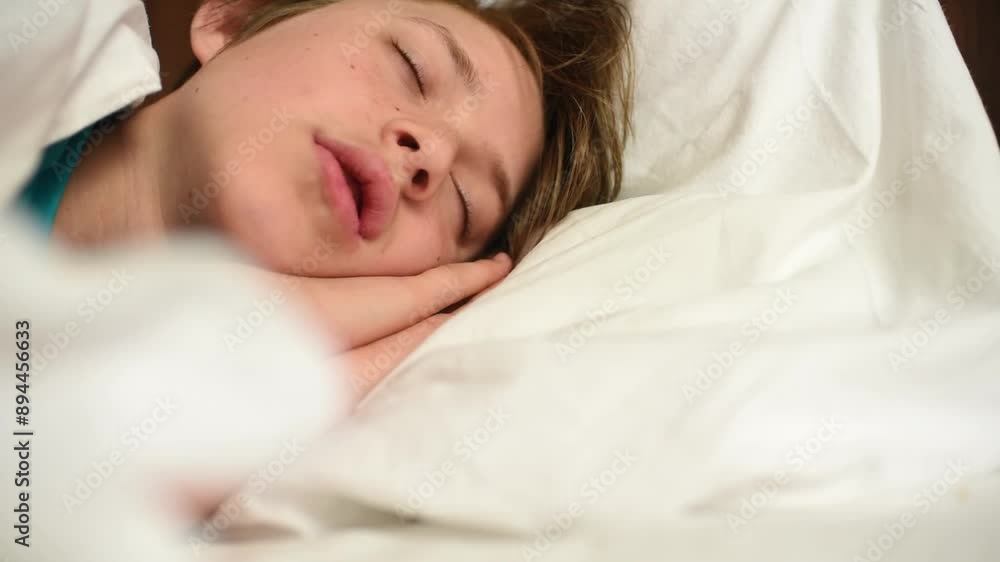 the boy sleeps on a white pillow, under a white blanket the boy sleeps on a white pillow, under a white blanket