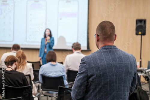 Business conference showing professional audience attentively listening to speaker's presentation in a corporate setting