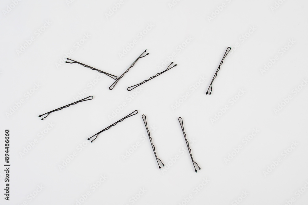 Black metal hair clips on white background