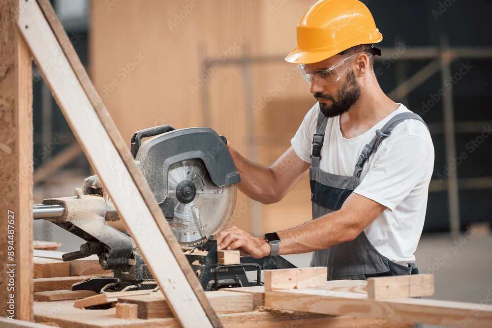 Process of cutting the wood. Industrial worker in warehouse Process of cutting the wood. Industrial worker in warehouse