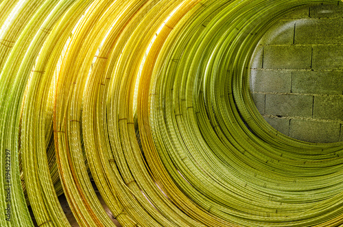 Yellow wires twisted into roll with visible details. Abstract industrial background. Wire texture. photo