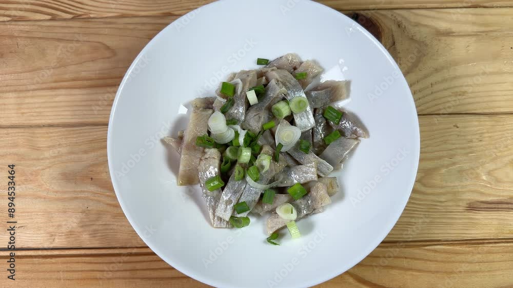 Sprinkling of sliced pickled herring with green onion on dish Sprinkling of sliced pickled herring with green onion on dish