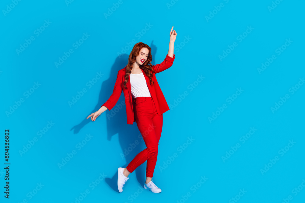 Full length photo of stunning gorgeous pretty lovely girl wear trendy red clothes have fun isolated on blue color background Full length photo of stunning gorgeous pretty lovely girl wear trendy red clothes have fun isolated on blue color background