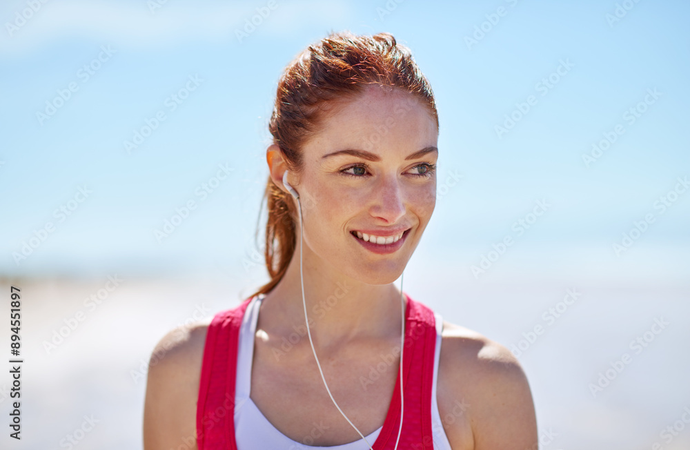 Fitness, smile and woman with headphones at beach for morning, run and listening to music. Athlete, female person and happy with audio tech by ocean for workout podcast, training and outdoor exercise