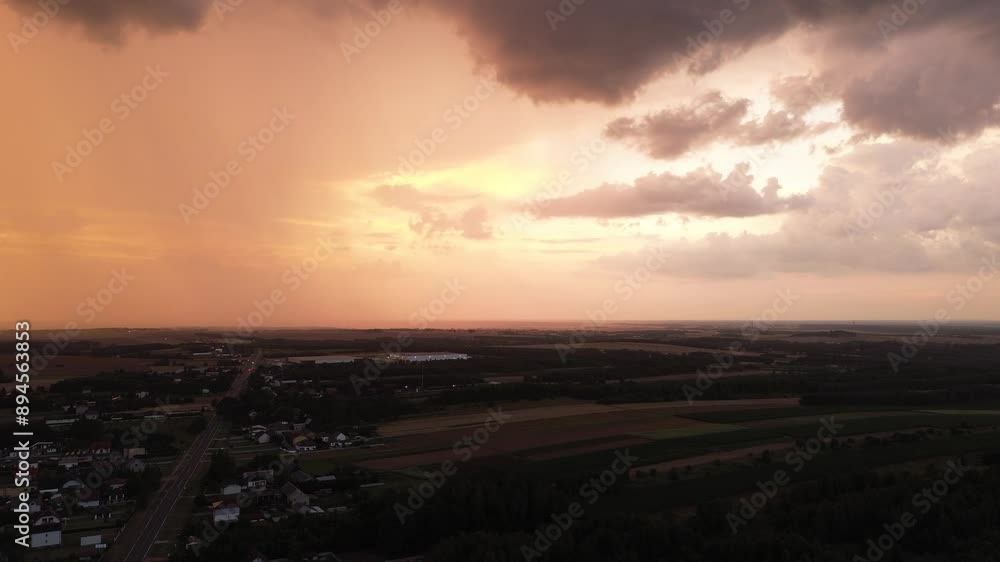 Dramatic sunset with rain and colorful clouds over fields Dramatic sunset with rain and colorful clouds over fields