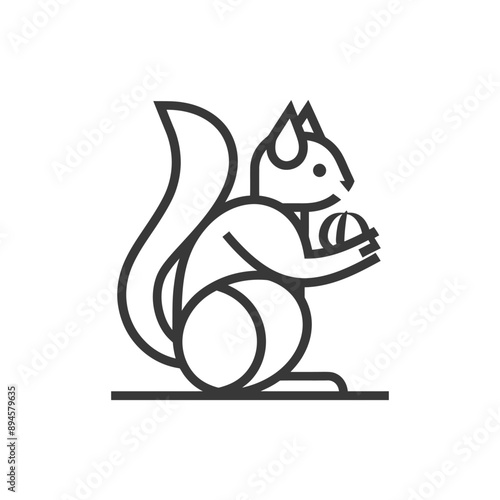 squirrel sits on its haunches and holds a nut in its paws