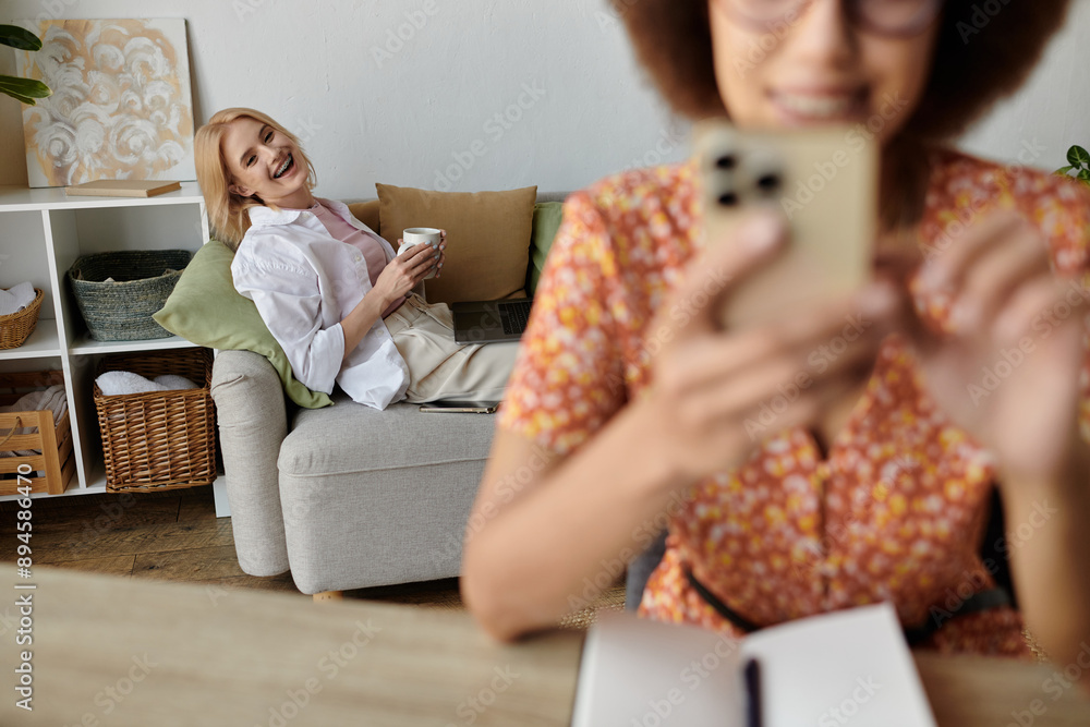 A woman relaxes on the couch while her partner works from home. A woman relaxes on the couch while her partner works from home.
