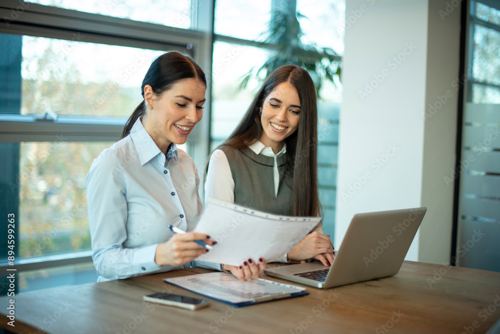 © Bojan - Two brunette business women discussing paper document at office. © Bojan - Two brunette business women discussing paper document at office.