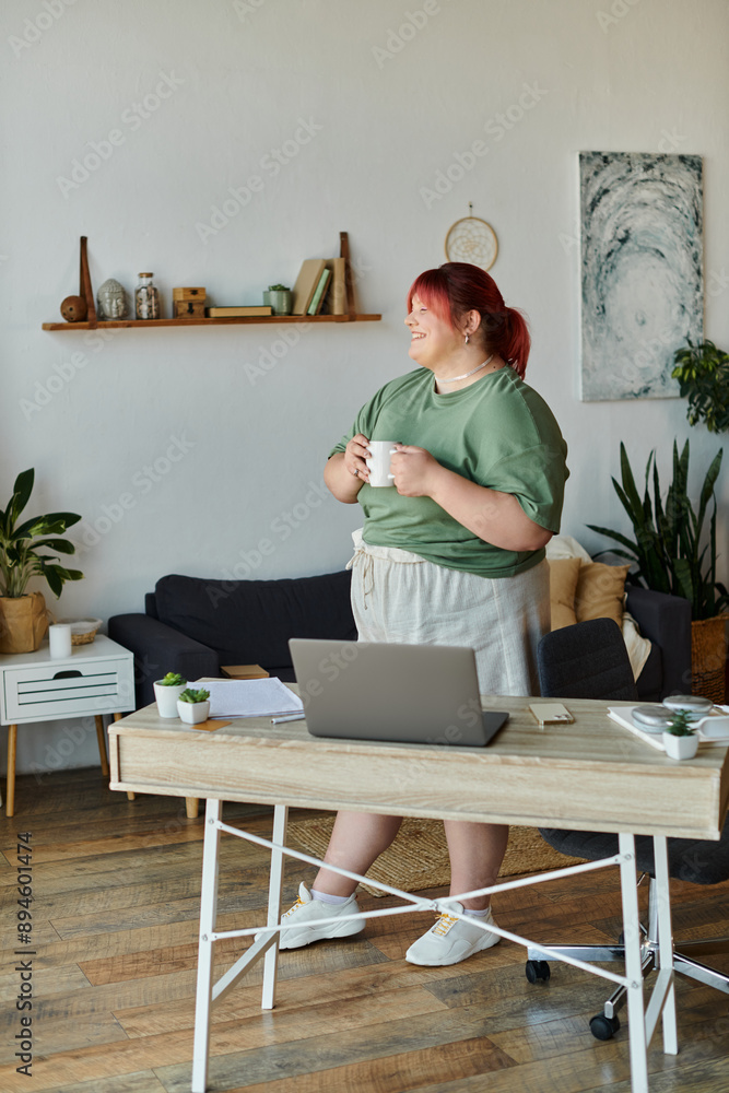 A woman stands by her desk, holding a mug of coffee and smiling. A woman stands by her desk, holding a mug of coffee and smiling.